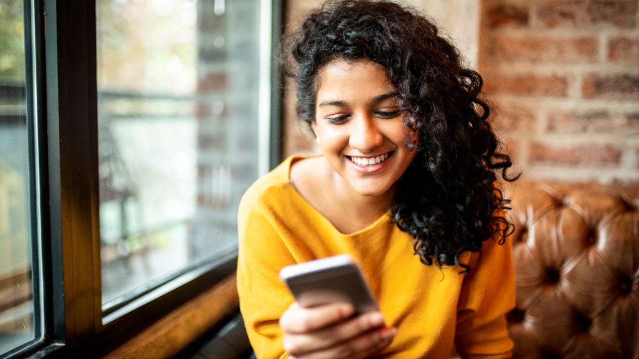 Woman using mobile phone at the bar