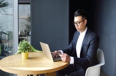 Well dressed Asian man making an online purchase