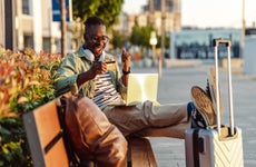 Man sitting on the bench and holding a credit card