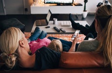 family sitting on couch watching tv