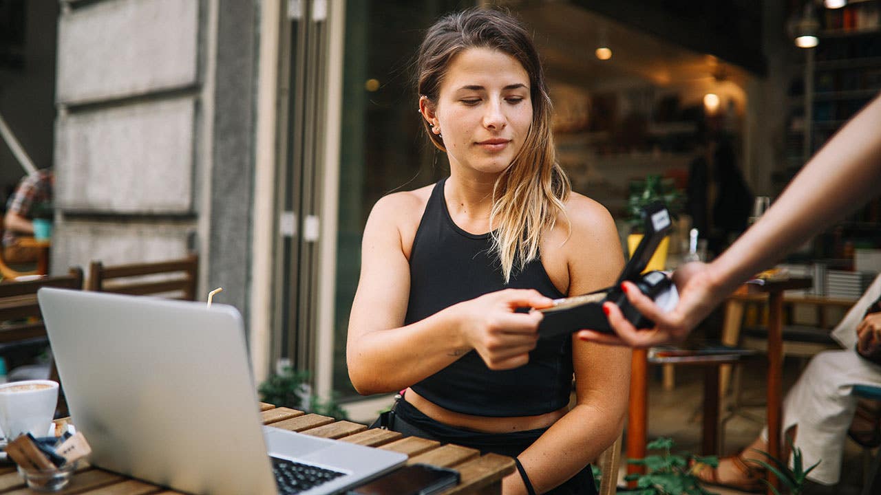 Young girl paying at a cafe