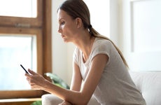 young woman looking at a cell phone at home