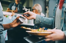 close up of hands making contactless payment using phone