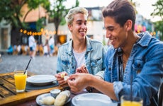 two men eating together at outdoor cafe