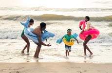 family playing together in the ocean waves on the beach