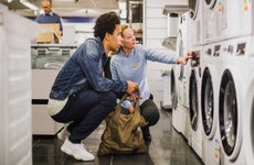 sales person talking to customer about a washing machine in a store