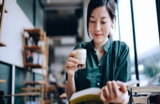 Woman reads a book in a cafe