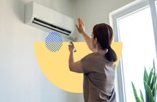 Woman using a remote to adjust an air conditioner's settings