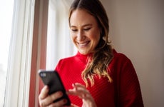 Woman texting on her smart phone and smiling