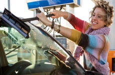 Woman in colorful top squeegeeing windshield