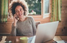 Woman on phone with laptop on table