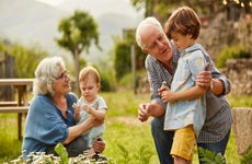 Grandparents talking to children in yard