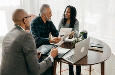 Two home buyers and a realtor discussing details at a round table