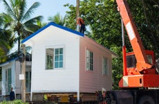 Prefabricated house crane being lifted by a crane