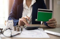 Women checking amount in bank account passbook with bank statement