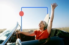 Older person driving a convertible and enjoying the breeze