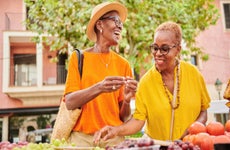 Two women shopping together at an outdoor food market