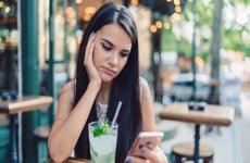 Depressed woman drinking mojito