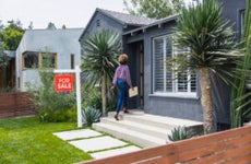 real estate agent carrying document while walking into house