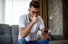 Young worried man working at home