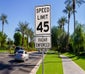 cars passing by a speeding limit sign