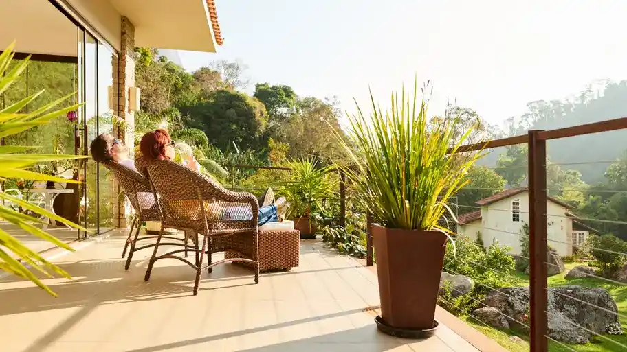 A couple sitting on a deck in lounge chairs, enjoying a relaxing moment together outdoors.