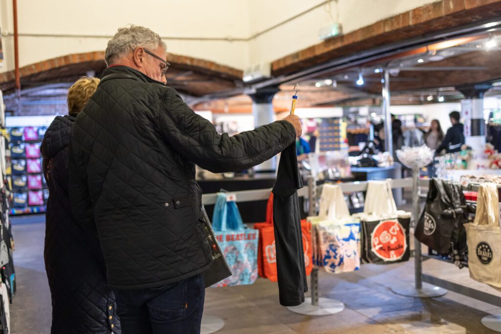 Visitors viewing t-shirts at Fab4 Store at The Beatles Story Liverpool