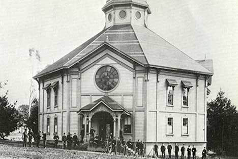 Historic black and white photo of polygonal building.