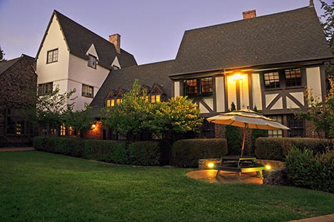 Tudor style building with lawn and hedges