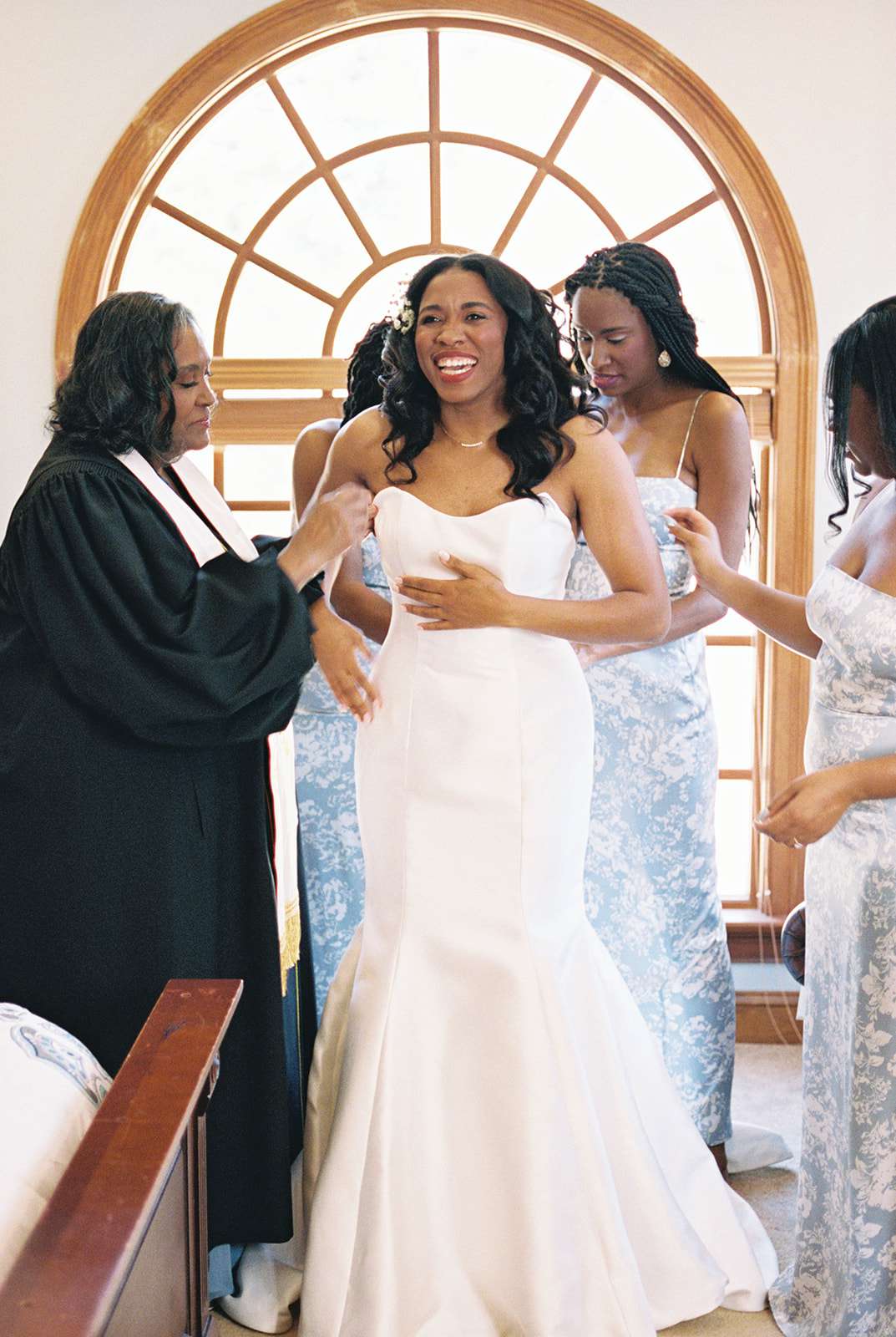 Bride Getting Ready in Wedding Dress With Bridesmaids in Blue Floral Dresses 