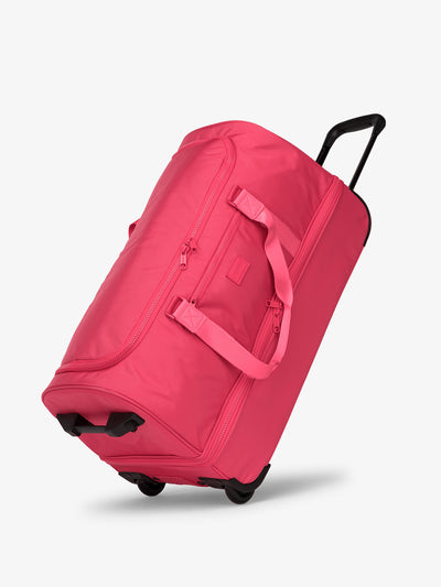 Side view of CALPAK Stevyn Large Rolling Duffel in dragonfruit pink; DRL2301-DRAGONFRUIT view 1