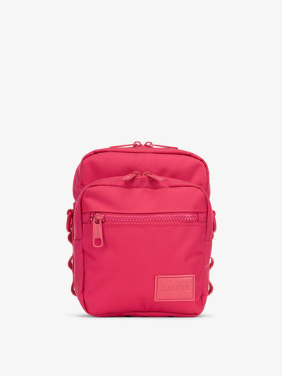 Front-view of CALPAK Stevyn Mini Crossbody Bag with zippered pockets and side panel daisy chains in pink dragonfruit; ACS2301-DRAGONFRUIT view 1