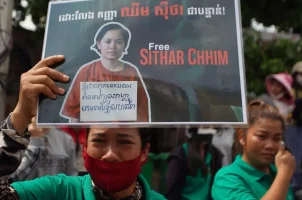 A supporter of Cambodia union leader Chhim Sithar holds up a placard outside Phnom Penh Municipal Court in Phnom Penh on May 25