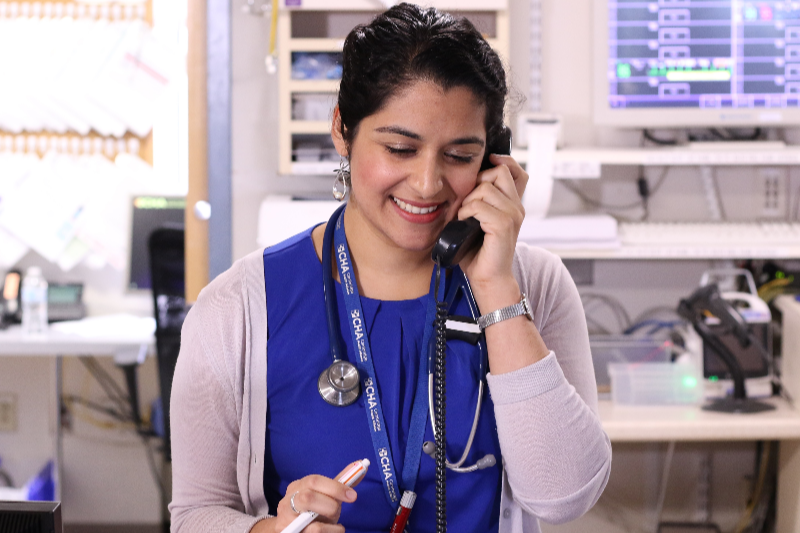 Portrait of Ariel Majid, MD on the phone in a clinical setting.