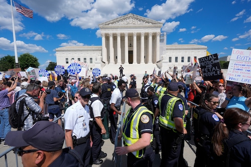 U.S. Supreme Court Police officers and U.S. Capitol Police officers place barriers between anti-abortion and abortion-rights demonstrators outside the Supreme Court, Monday, June 24, 2024, in Washington.