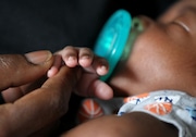 Njkema Smith, 36, holds her 6-week-old son  Walter Bryant Malloy in Baltimore on Wednesday, July 29, 2015.  He was born seven weeks early by emergency c-section due to a condition called placenta previa, which can cause life-threatening blood loss during delivery. He weighed 3 pounds, 13 ounces and spent three weeks gaining strength in the neonatal intensive care unit and another five days on a regular hospital floor. Celeste Spears, the lead family support advocate for a Baltimore child welfare agency called The Family Tree, pays a home visit to Njkema Smith once a week. Spears is also a home visitor for the BÕMore for Healthy Babies initiative. ItÕs her job to visit new and expectant moms in South Baltimore at elevated risk of having problems in their pregnancies that could threaten their health or the lives of their babies.  The Family Tree has been providing prenatal home visits for more than a decade. In 2009 when the BÕMore initiative began, theirs was one of nine such programs across the city, all with widely varying services, eligibility criteria, staff training levels, and overlapping recruitment efforts. The result was a patchwork, uncoordinated effort with no accountability that left many women in the city without services, she said. Tackling that mess was one of BÕMoreÕs first orders of business. Today, five home visiting programs, all using evidence-based content and trained staffs, are able to reach 378 more women each year.    (Lisa DeJong/The Plain Dealer) ORG XMIT: CLE1512051625060112 The Plain Dealer