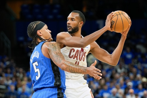 Cleveland Cavaliers forward Evan Mobley, right, looks to pass the ball as Orlando Magic forward Paolo Banchero (5) defends during the first half of Game 4 of an NBA basketball first-round playoff series, Saturday, April 27, 2024, in Orlando, Fla. (AP Photo/John Raoux)