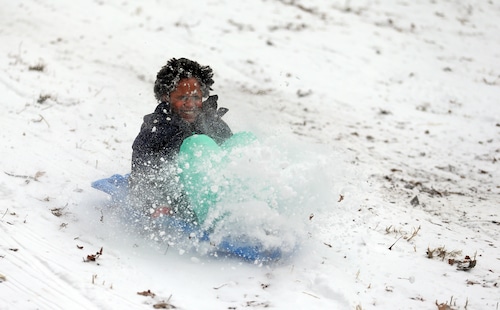 Families enjoy sledding of the freshly-fallen snow at the Huntington Reservation in Bay Village.