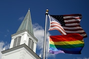 FILE - In this April 19, 2019 file photo, a gay pride rainbow flag flies along with the U.S. flag in front of the Asbury United Methodist Church in Prairie Village, Kan. On Friday, April 26, 2019, the United Methodist Church's judicial council upheld the legality of major portions of a new plan that strengthens the denomination's bans on same-sex marriage and ordination of LGBT pastors. (AP Photo/Charlie Riedel)