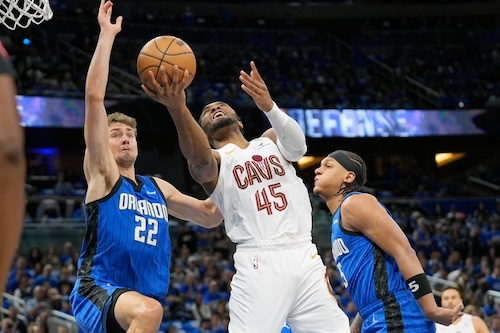 Cleveland Cavaliers guard Donovan Mitchell (45) gets between Orlando Magic forward Franz Wagner (22) and forward Paolo Banchero for a shot during the first half of Game 4 of an NBA basketball first-round playoff series, Saturday, April 27, 2024, in Orlando, Fla. (AP Photo/John Raoux)