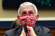 Dr. Anthony Fauci, director of the National Institute of Allergy and Infectious Diseases, wears a face mask bearing the name of the Major League Baseball Washington Nationals as he prepares to testify at a hearing of the U.S. House Committee on Energy and Commerce on Capitol Hill on June 23, 2020 in Washington, DC. Fauci is scheduled to throw out the ceremonial first pitch to begin the 2020 Major League Baseball season. (Kevin Dietsch/Pool/Getty Images/TNS) TNS