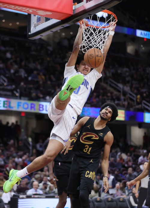 Orlando Magic guard Anthony Black dunks the ball defended by Cleveland Cavaliers center Jarrett Allen