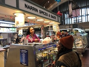 Narrin Carlberg talks with customer Mia Gatewood, who purchased a bottle of hot sauce from Carlberg's stand at the West Side Market.