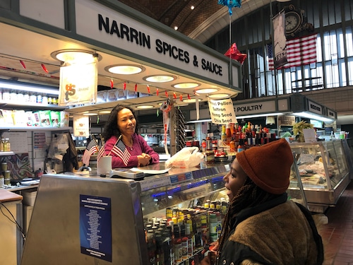 Narrin Carlberg talks with customer Mia Gatewood, who purchased a bottle of hot sauce from Carlberg's stand at the West Side Market