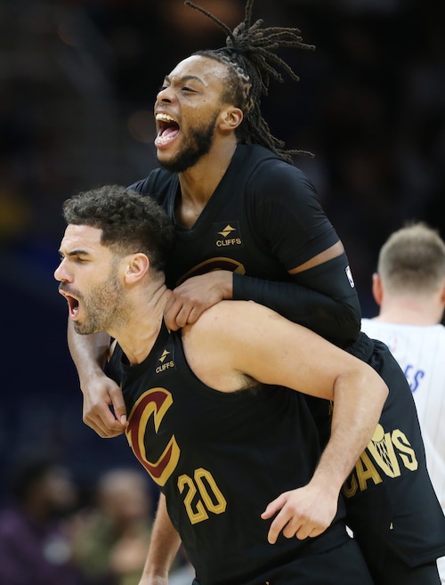 Cleveland Cavaliers guard Darius Garland jumps on the back of Cleveland Cavaliers forward Georges Niang celebrating Niang’s three-point score in the second half