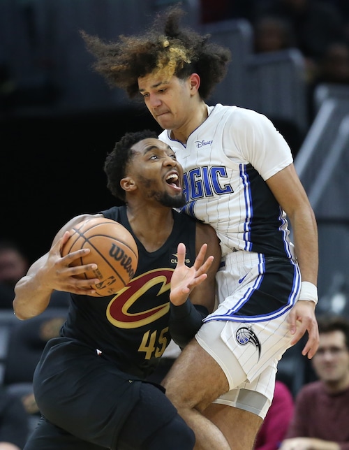 Cleveland Cavaliers guard Donovan Mitchell runs into the defense of Orlando Magic guard Anthony Black