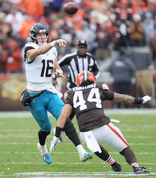 Jacksonville Jaguars quarterback Trevor Lawrence is able to get a pass off for a first down covered by Cleveland Browns linebacker Sione Takitaki in the first half at Cleveland Browns Stadium.
