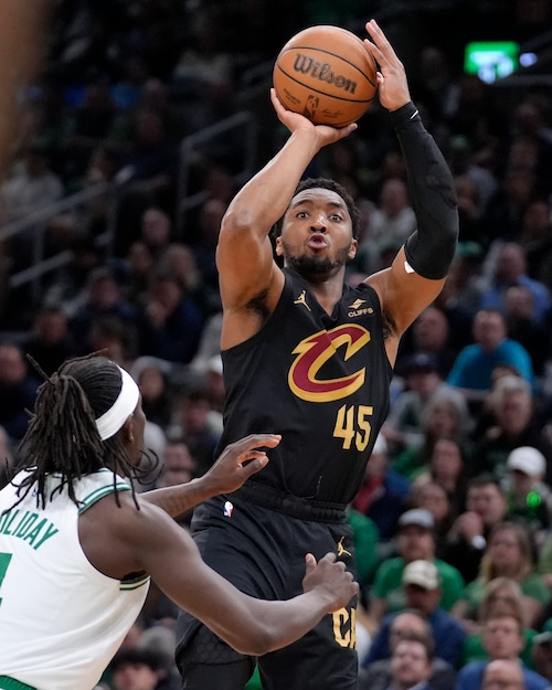 Cleveland Cavaliers guard Donovan Mitchell (45) shoots next to Boston Celtics guard Jrue Holiday (4) during the second half of Game 2 of an NBA basketball second-round playoff series Thursday, May 9, 2024, in Boston. (AP Photo/Steven Senne)