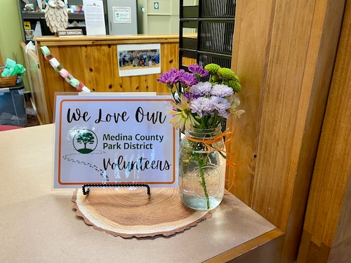 Sign and flowers celebrating park volunteers