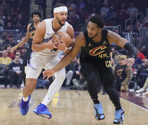 Orlando Magic guard Jalen Suggs secures a loose basketball from Cleveland Cavaliers guard Donovan Mitchell